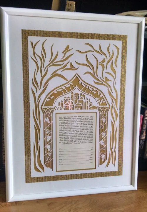 Detail shot of laser cut paper overlaid on top of a sheet of gold paper. Finished Ketubah Finished Ketubah