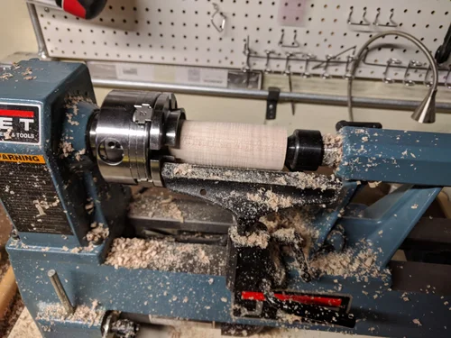 The wood I am using for this handle is an old maple table leg that has some curl in it. The blank is rounded and put in a chuck.